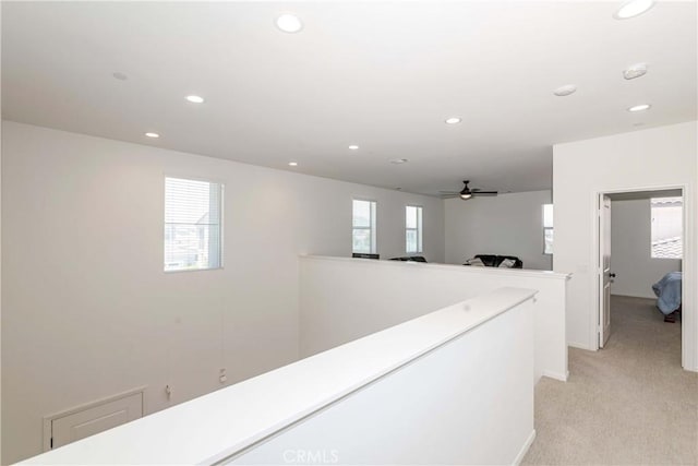 hallway featuring recessed lighting, an upstairs landing, and light colored carpet