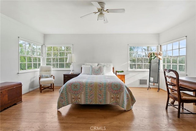 bedroom featuring visible vents, ceiling fan, baseboards, and wood finished floors