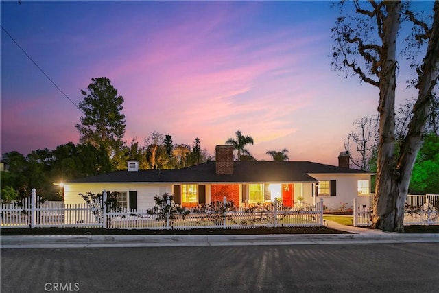 ranch-style home featuring a fenced front yard and a chimney