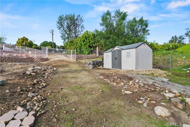 view of yard with an outbuilding, a storage unit, and fence