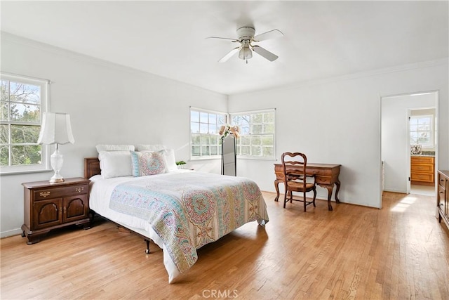 bedroom with light wood-type flooring, ornamental molding, and a ceiling fan