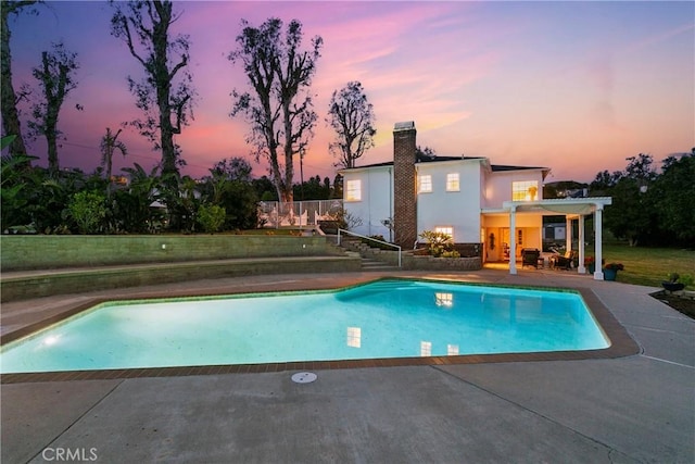 outdoor pool with a patio area and a lawn