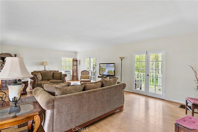 living room with french doors, light wood-style floors, and baseboards