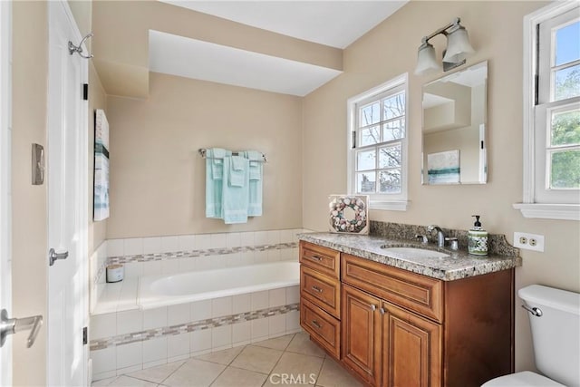 bathroom with tile patterned floors, toilet, vanity, and a garden tub