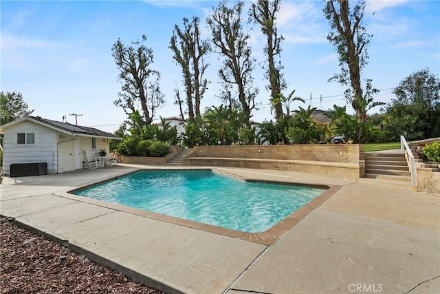 outdoor pool with stairway and a patio