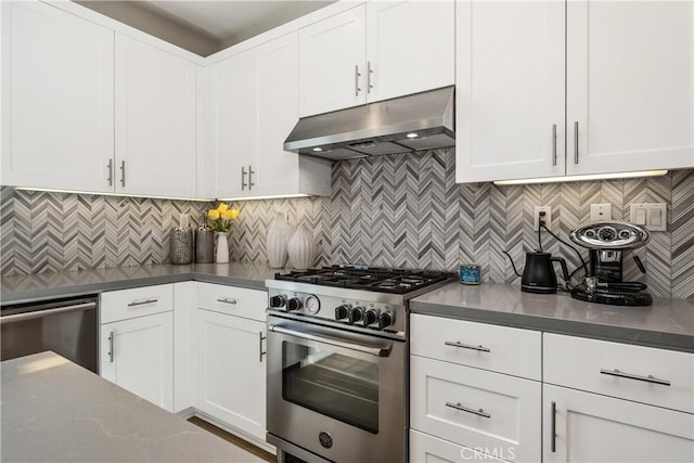 kitchen with under cabinet range hood, tasteful backsplash, appliances with stainless steel finishes, and white cabinetry