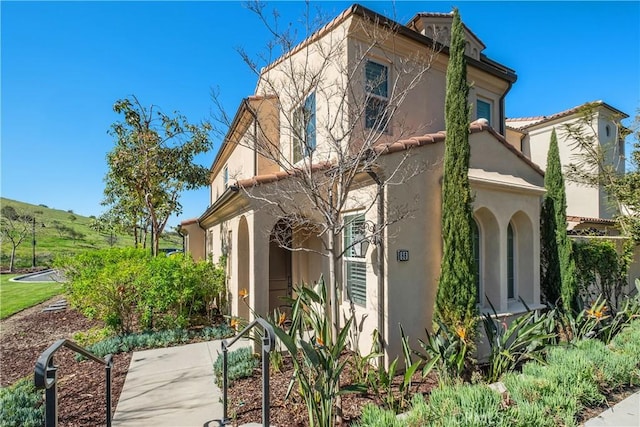 view of property exterior featuring stucco siding and a tile roof