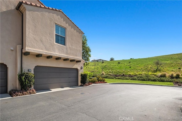 view of property exterior with driveway and stucco siding