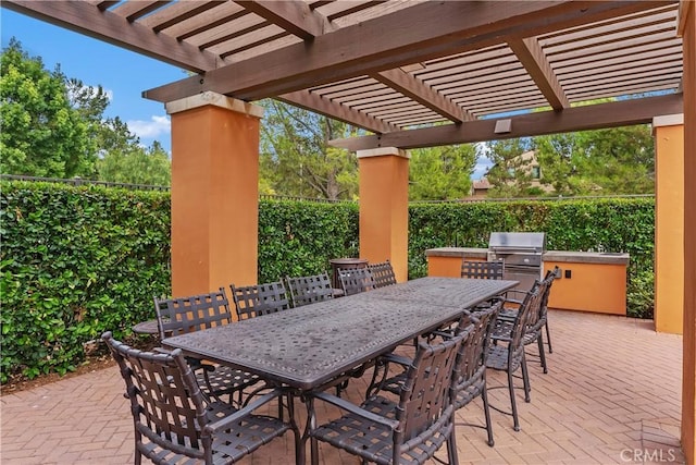 view of patio featuring area for grilling, exterior kitchen, outdoor dining area, and fence