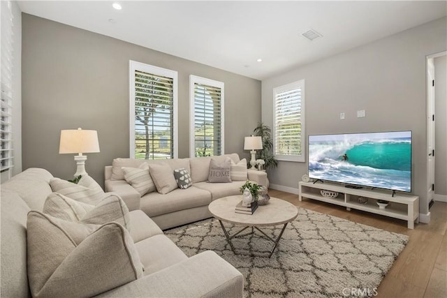 living room with visible vents, recessed lighting, baseboards, and wood finished floors