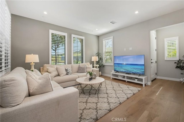 living area featuring recessed lighting, baseboards, and hardwood / wood-style floors