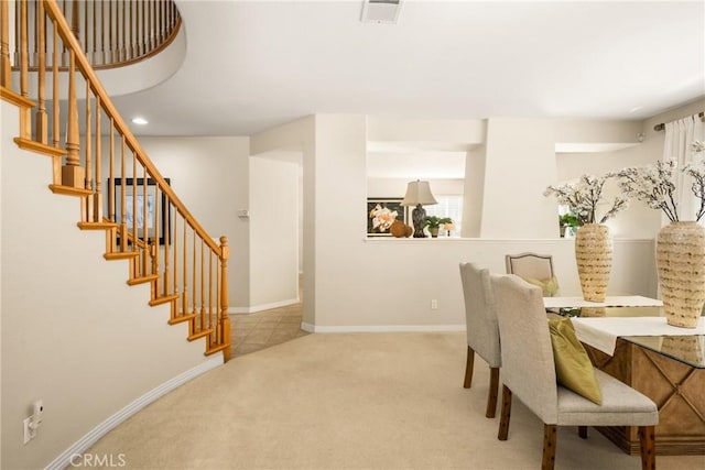 carpeted dining area featuring visible vents, baseboards, and stairs