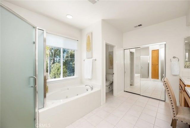 bathroom with visible vents, toilet, a whirlpool tub, tile patterned floors, and vanity