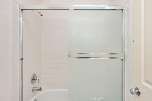 bathroom with shower / bath combination with glass door