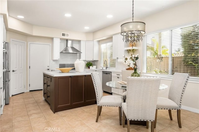 kitchen with visible vents, dishwasher, light countertops, white cabinetry, and wall chimney exhaust hood