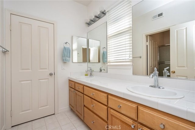 bathroom featuring double vanity, visible vents, tile patterned floors, and a sink