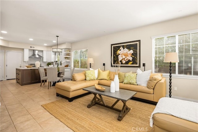 living area featuring visible vents, baseboards, light tile patterned floors, recessed lighting, and a notable chandelier