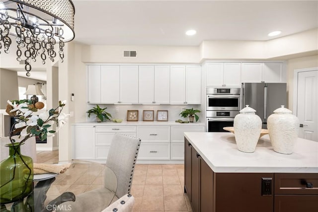 kitchen featuring visible vents, appliances with stainless steel finishes, white cabinets, and light countertops