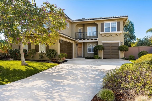 view of front of property featuring a front yard, a balcony, fence, driveway, and stucco siding