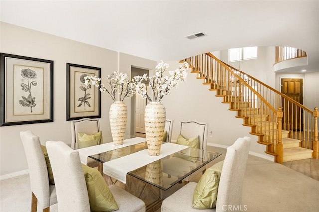 carpeted dining space with visible vents, baseboards, and stairs