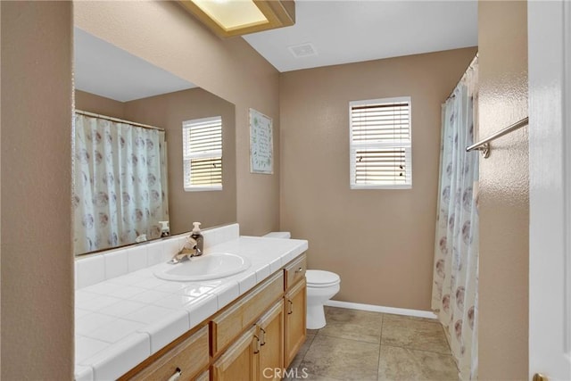 bathroom featuring baseboards, toilet, vanity, and tile patterned flooring