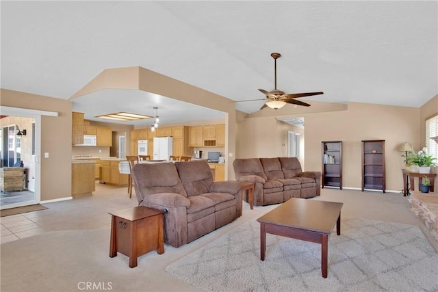 living room featuring light carpet, a ceiling fan, light tile patterned flooring, baseboards, and vaulted ceiling