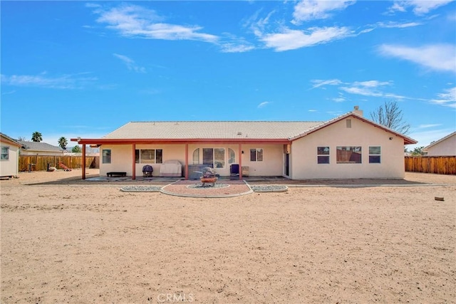 back of house with a patio, fence, and a fire pit