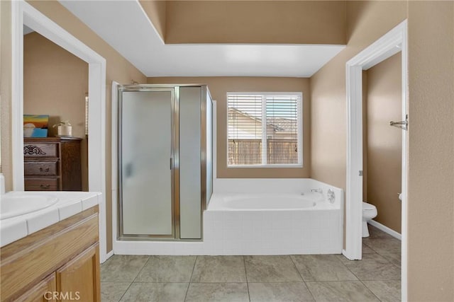 full bathroom featuring vanity, a garden tub, toilet, and a stall shower