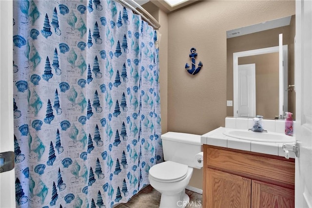 bathroom with a shower with shower curtain, toilet, vanity, and a textured wall