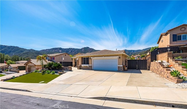 view of front of house featuring a gate, a garage, a mountain view, and driveway