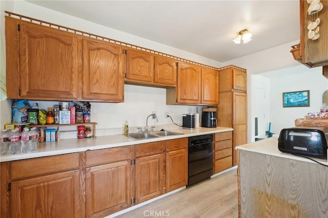 kitchen with a sink, light wood-style floors, dishwasher, and brown cabinetry