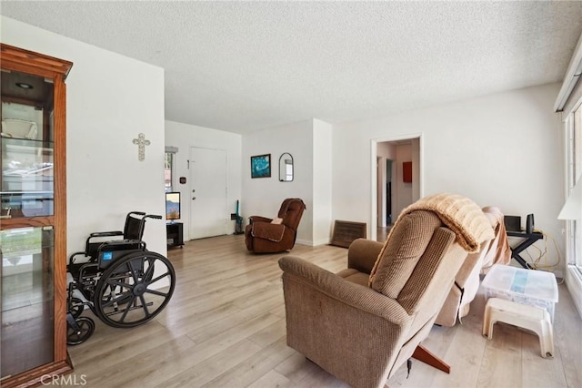 living room with a textured ceiling and light wood-style floors