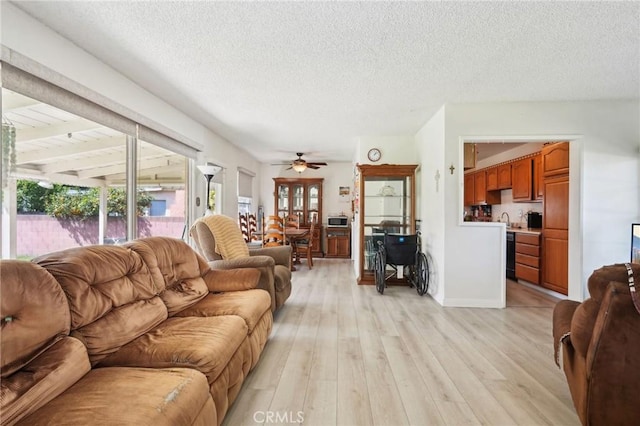 living room featuring light wood-type flooring, a wealth of natural light, and a textured ceiling