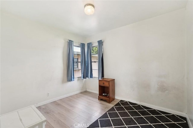 empty room with light wood-style flooring and baseboards