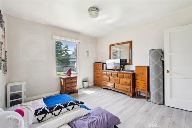 bedroom with light wood-style flooring and baseboards