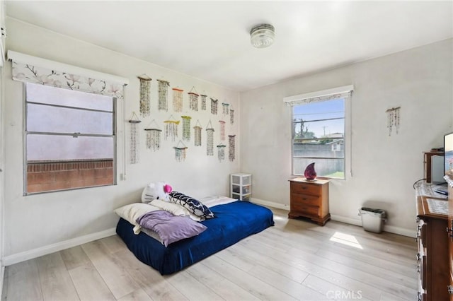 bedroom featuring baseboards and wood finished floors