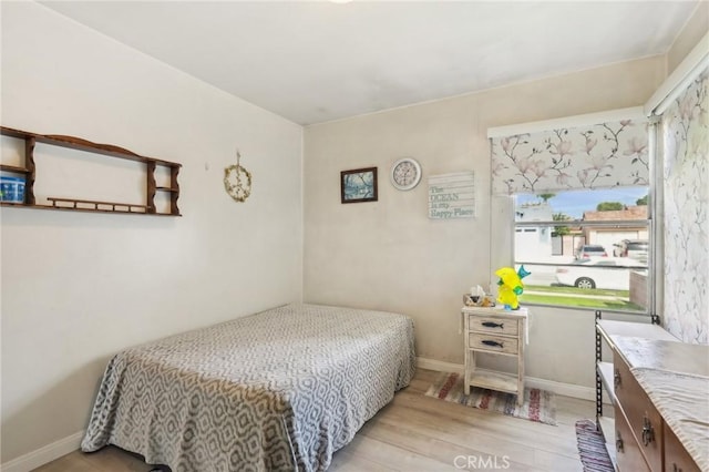 bedroom with wood finished floors and baseboards