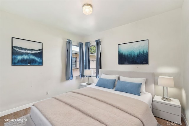 bedroom featuring wood finished floors and baseboards