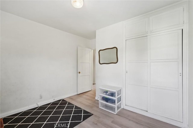 interior space with baseboards and wood finished floors