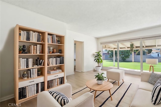 sitting room with baseboards and wood finished floors