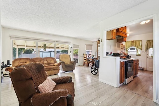 living room with light wood-style flooring, a textured ceiling, and ceiling fan