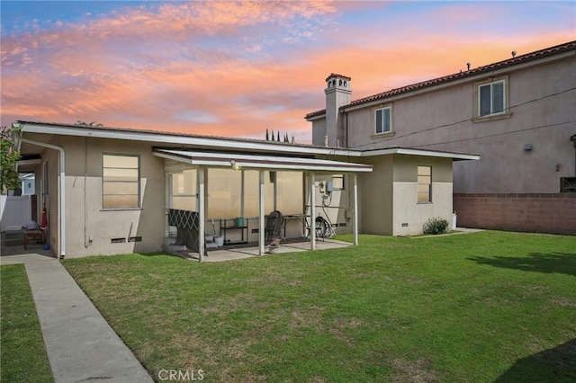 back of house featuring crawl space, stucco siding, a patio, and a yard