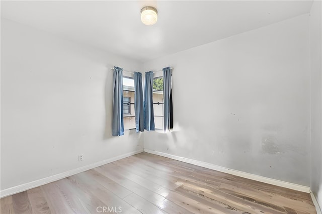 spare room featuring wood finished floors and baseboards