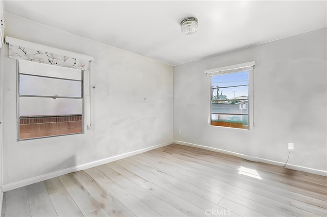 empty room featuring baseboards and wood finished floors