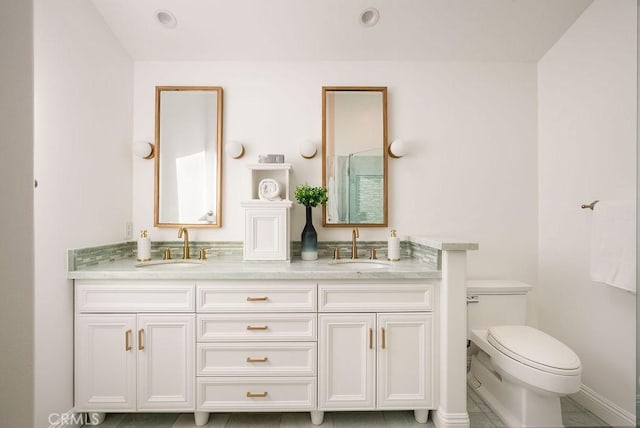 full bathroom with double vanity, toilet, and a sink