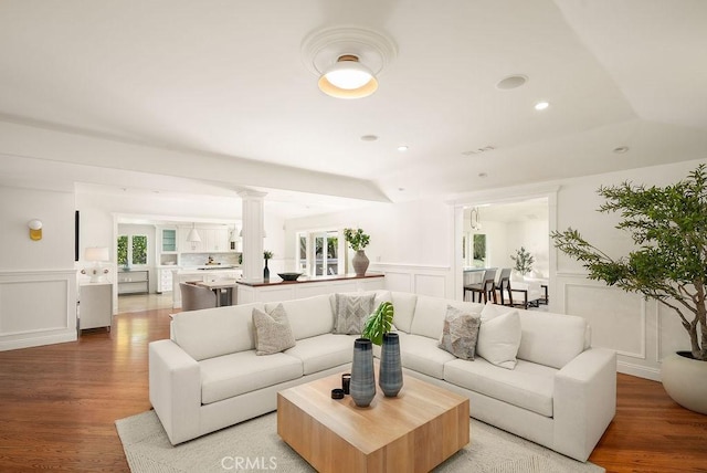 living area with recessed lighting, a wainscoted wall, light wood-style flooring, and a decorative wall