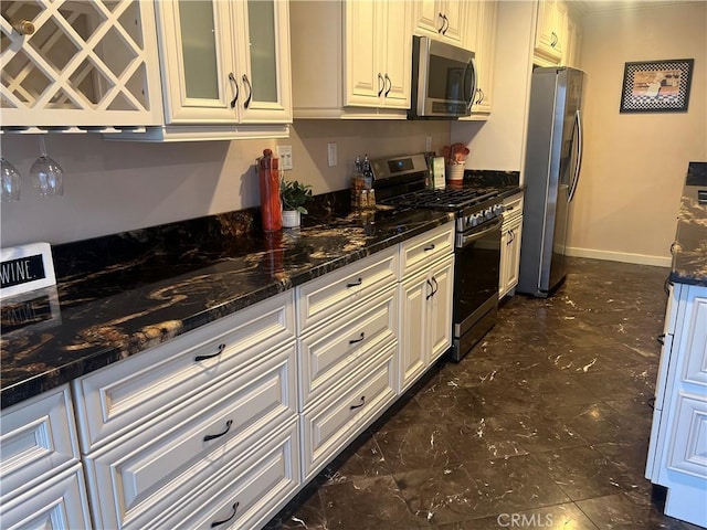 kitchen with baseboards, glass insert cabinets, dark stone countertops, and stainless steel appliances