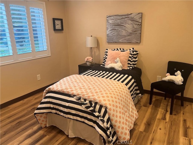bedroom featuring baseboards and wood finished floors