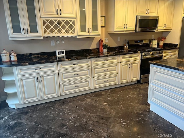 kitchen with open shelves, dark stone counters, appliances with stainless steel finishes, and glass insert cabinets