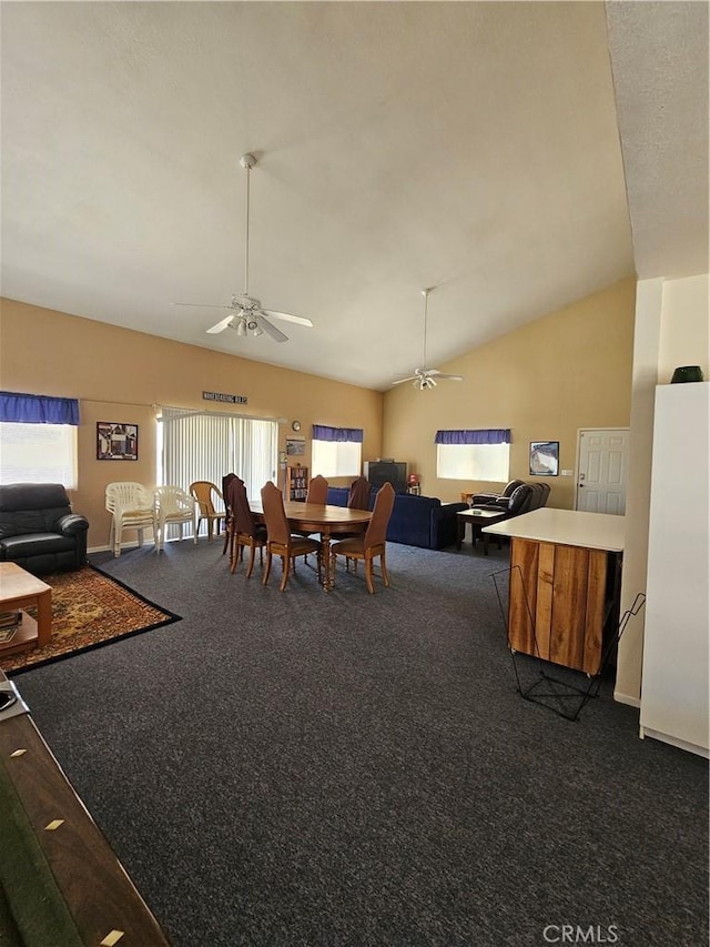 dining room featuring dark carpet, high vaulted ceiling, and a ceiling fan